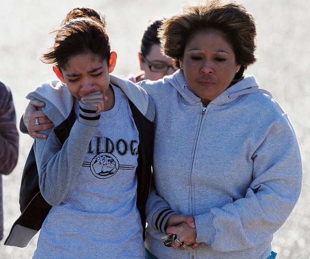 A student, left, is hugged following a shooting at Berrendo Middle School, Tuesday, Jan. 14, 2014, in Roswell, N.M. A shooter opened fire at the middle school, injuring at least two students befor ...