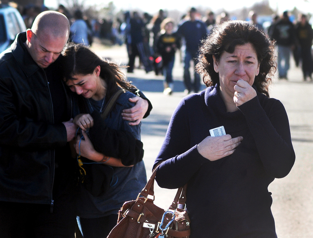 A woman waits at a staging ground area where families are being reunited with Berrendo Middle School students after a shooting at the school, Tuesday, Jan. 14, 2014, in Roswell, N.M. A shooter ope ...