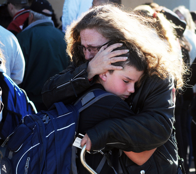 A woman hugs a student at a staging ground set up at the Roswell Mall following a shooting at Berrendo Middle School, Tuesday, Jan. 14, 2014, in Roswell, N.M. A shooter opened fire at the middle s ...