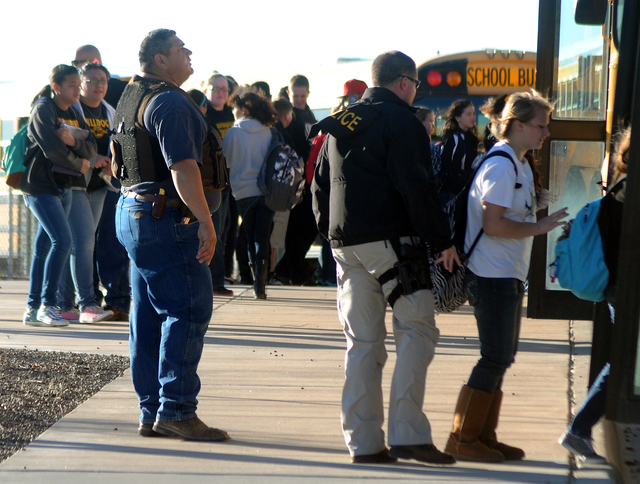 Authorities stand guard as students are escorted from Berrendo Middle School after a shooting, Tuesday, Jan. 14, 2014, in Roswell, N.M. A shooter opened fire at the middle school, injuring at leas ...