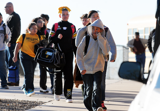 Students are escorted from Berrendo Middle School after a shooting, Tuesday, Jan. 14, 2014, in Roswell, N.M. A shooter opened fire at the middle school, injuring at least two students before being ...