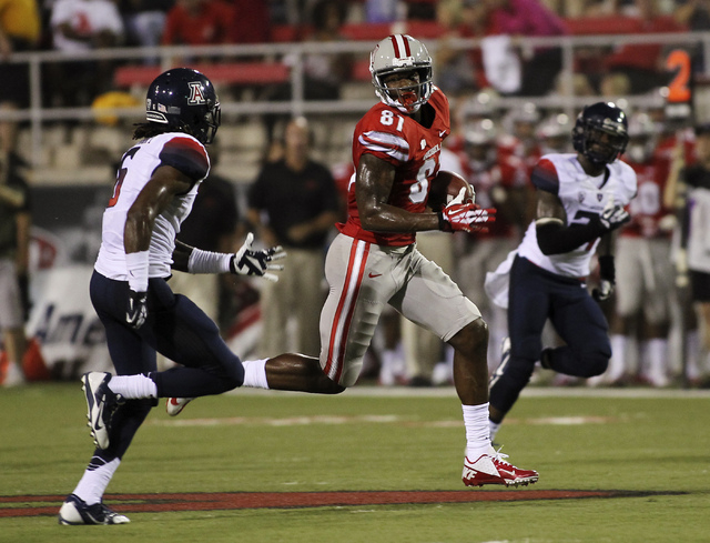 UNLV's Devante Davis (81) runs past the University of Arizona's Jonathan McKnight, left, and Marquis Flowers for a touchdown during the first half at Sam Boyd Stadium in Las Vegas on Sept. 7, 2013 ...