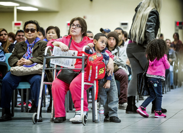 Ramiro Mendoza, 5, leans against Graciel Renteria while she waits to gets and ID at the Department of Motor Vehicles office, 2701 E. Sahara Avenue on Friday, Jan. 17, 2014. The DMV conducts facia ...