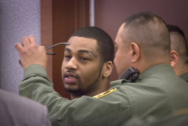 A Las Vegas police officer removes glasses from Ammar Harris in Clark County District Court on Wednesday. District Court Judge Kathleen Delaney agreed to postpone sentencing for six weeks for Harr ...
