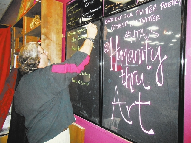 Adam Littman, founder and artistic director of Humanity Thru Art, writes on the blackboard at Dead Poet Books, 937 S. Rainbow Blvd., Dec. 3 for that night’s program, Foundations of Vocal Perform ...