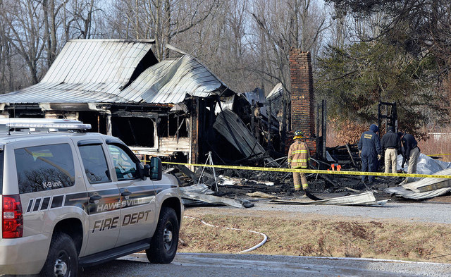 Members of the Kentucky State Fire Marshall's office look over the remains of a house fire near Greenville, Ky., Thursday. Nine people were killed in the fire in rural western Kentucky and two peo ...