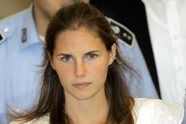 Then murder suspect Amanda Knox is escorted by Italian penitentiary police officers from Perugia's court after a hearing, central Italy on Sept. 16, 2008. (AP Photo/Antonio Calanni, File)