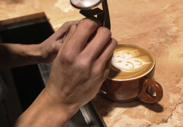 Barista Lawrence Chung creates art in cups of latte at Leone Cafe in Tivoli Village. (Jerry Henkel/Las Vegas Review-Journal)
