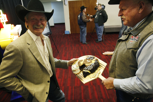 Las Vegas Convention and Visitors Authority Chairman Tom Collins, right, shows PRCA Chairman Karl Stressman a horse head cake after the LVCVA approved a deal to keep the National Finals Rodeo in L ...