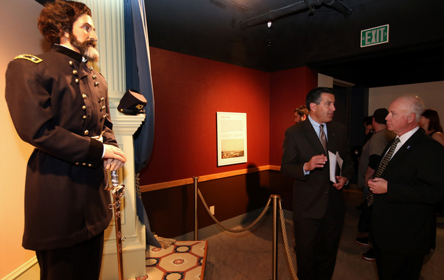 Gov. Brian Sandoval and state Museums and History Director Peter Barton talk at the "Finding Fremont: Pathfinder of the West" exhibit grand opening at the Nevada State Museum, in Carson  ...