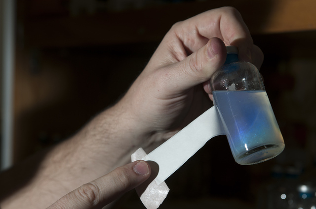 Scott Hamilton-Brehm, postdoctoral researcher at Desert Research Institute, shows a colorful chemical called dodecylamine that causes bacteria to germinate from spores at the Desert Research Insti ...