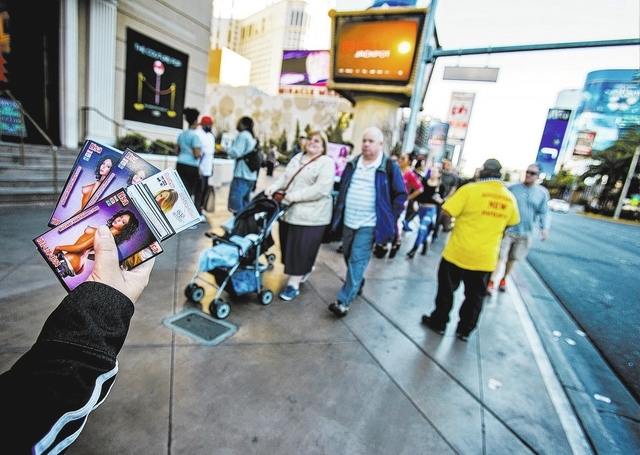 A woman passes out smut cards in front of Paris Las Vegas hotel & casino, 3655 South Las Vegas Boulevard, on Wednesday, Jan. 15, 2014. Some businesses use the moniker Sin CityӠlabel to g ...