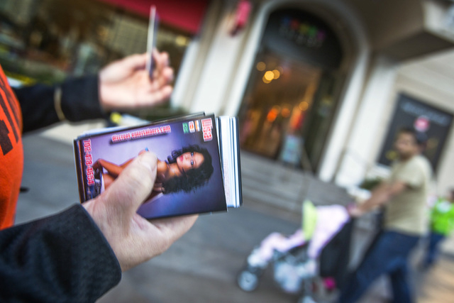 A woman passes out smut cards  in front of Paris Las Vegas hotel & casino, 3655 South Las Vegas  Boulevard, on Wednesday, Jan. 15, 2014.  Some businesses use the moniker Sin CityӠlabel  to g ...