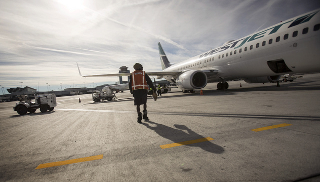 A ground crew at McCarran International Airport prepares a WestJet for takeoff on Tuesday, Dec. 24, 2013. The  Canadian airline company will become the first foreign airline to take one million pe ...