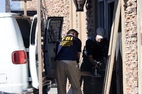 FBI agents board up a glass door that was broken when agents served a search warrant at Leon Benzer's offices in September 2008. Benzer is among nearly 40 conspirators charged in a scheme to tak ...