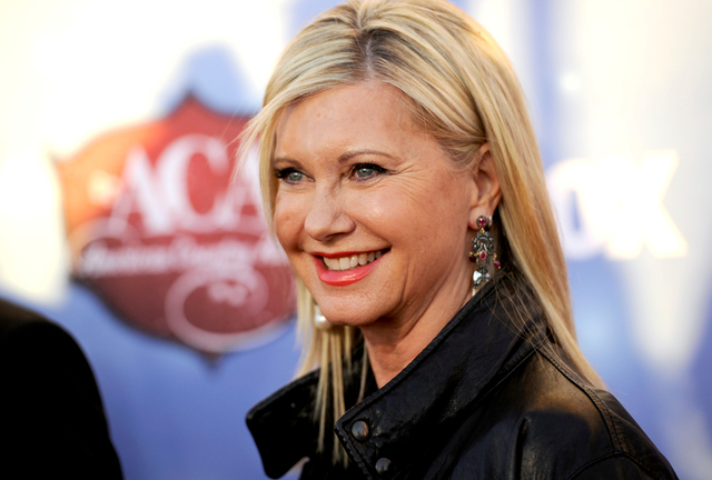 In this Tuesday, Dec. 10, 2013, file photo, Olivia Newton-John arrives at the American Country Awards at the Mandalay Bay Resort & Casino, in Las Vegas. The 65-year-old singer and actress announce ...