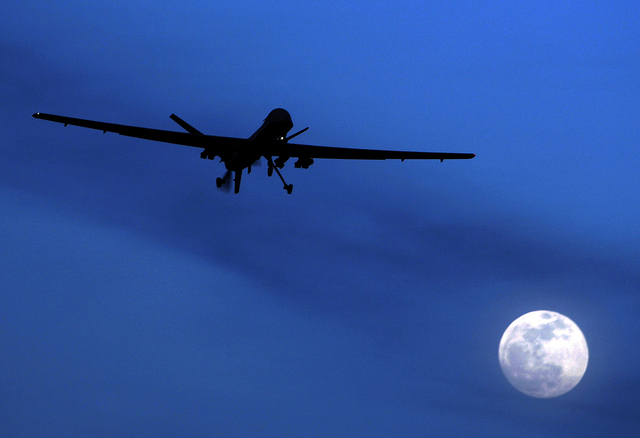 An unmanned U.S. Predator drone flies over Kandahar Air Field in southern Afghanistan in late January. (AP Photo/Kirsty Wigglesworth, file)
