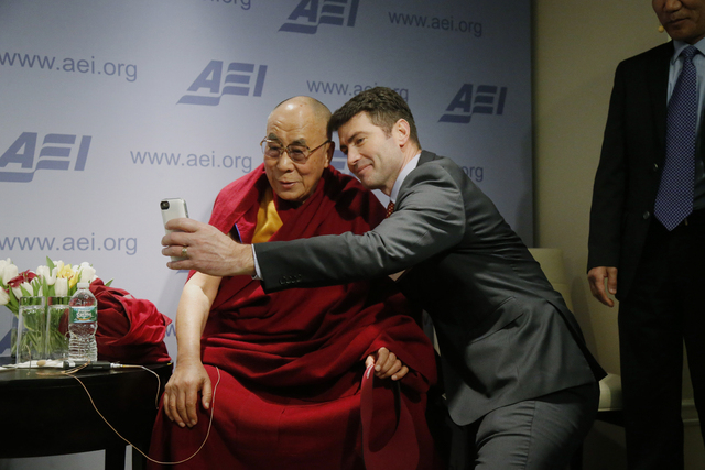 Tibetan spiritual leader the Dalai Lama poses for a "selfie" with blogger and activist Alek Boyd during a break between panel discussions at an event entitled: "Happiness, Free Ente ...