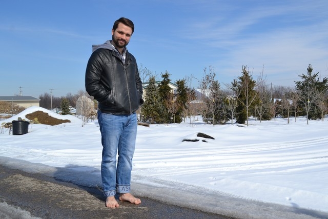 Richard Hudgins stands barefoot near snow in Louisville, Ky., on Wednesday, Feb. 12, 2014. Hudgins is going barefoot for a year and through a harsh winter to raise money for African school childre ...