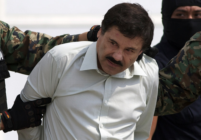 Joaquin "El Chapo" Guzman is escorted to a helicopter in handcuffs by Mexican navy marines at a navy hanger in Mexico City, Saturday, Feb. 22, 2014. A senior U.S. law enforcement official said Sat ...