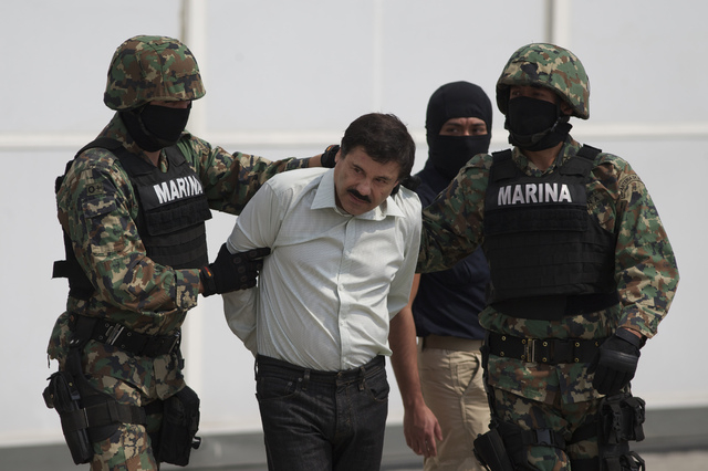 Joaquin "El Chapo" Guzman is escorted to a helicopter in handcuffs by Mexican navy marines at a navy hanger in Mexico City, Mexico, Saturday, Feb. 22, 2014. A senior U.S. law enforcement official  ...