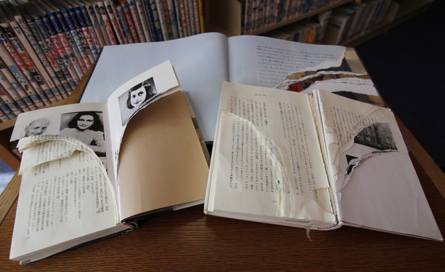 Ripped copies of Anne Frank's "Diary of a Young Girl" and related books are shown at Shinjuku City Library in Tokyo Friday, Feb. 21, 2014. Tokyo Libraries said on Friday that hundreds of ...