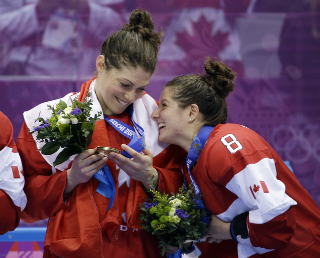 Members of team Canada react while receiving their gold medals after beating the USA 3-2 in overtime of the gold medal women's ice hockey game at the 2014 Winter Olympics, Wednesday, Feb. 19, 2014 ...