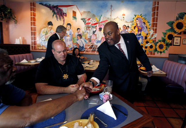 Niger Innis shakes hands with North Las Vegas Constable Herb Brown, not pictured, while Tom Jeeves, left, waits to hear Innis speak at the Hispanics in Politics at Dona Maria Tamales restaurant in ...