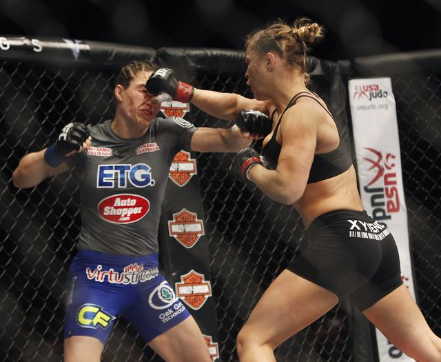 Ronda Rousey, right, lands a punch to the face of Sara McMann during UFC 170 at the Mandalay Bay Events Center in Las Vegas on Saturday night, Feb. 22, 2014. Rousey retained her Women's Bantamweig ...