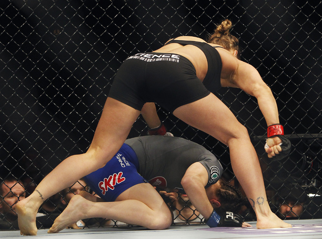 Ronda Rousey pounds on Sara McMann after delivering a decisive knee during UFC 170 at the Mandalay Bay Events Center in Las Vegas on Saturday night, Feb. 22, 2014. Rousey retained her Women's Bant ...