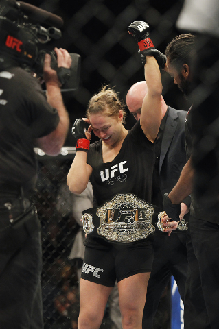 Ronda Rousey has her belt put on her by UFC President Dana White after defeating Sara McMann during UFC 170 at the Mandalay Bay Events Center in Las Vegas on Saturday night, Feb. 22, 2014. Rousey  ...