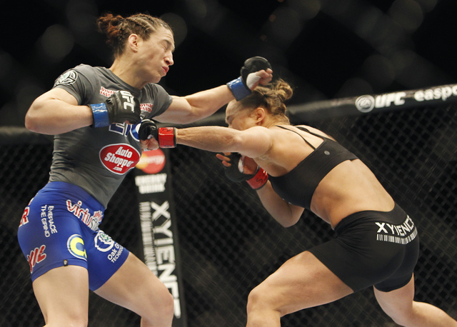 Ronda Rousey, right, lands a punch to the chest of Sara McMann during UFC 170 at the Mandalay Bay Events Center in Las Vegas on Saturday night, Feb. 22, 2014. Rousey retained her Women's Bantamwei ...