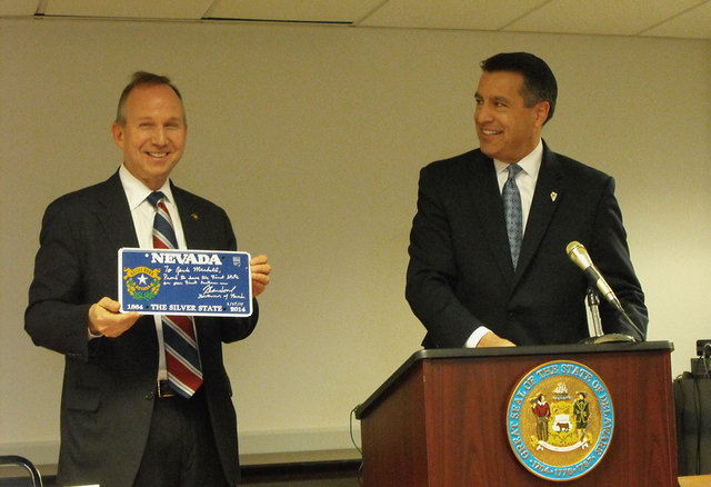 Delaware Gov. Jack Markell holds a souvenir Nevada sesquicentennial license plate, presented to him by Nevada Gov. Brian Sandoval at a signing ceremony for an online poker agreement between the tw ...
