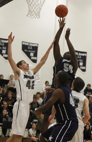 Agassi Prep’s Wa’T Manor (50) shoots over The Meadows’ Brandon Rufty (42) ...