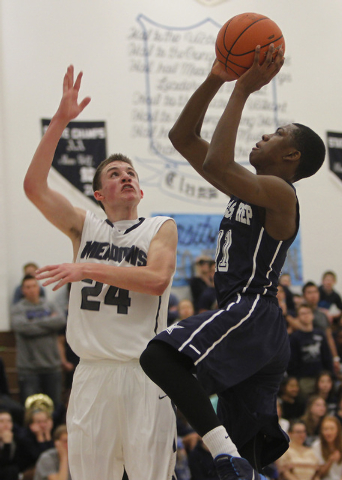 Agassi Prep’s Deishuan Booker (11) shoots over The Meadows’ Jake Epstein (24) on ...