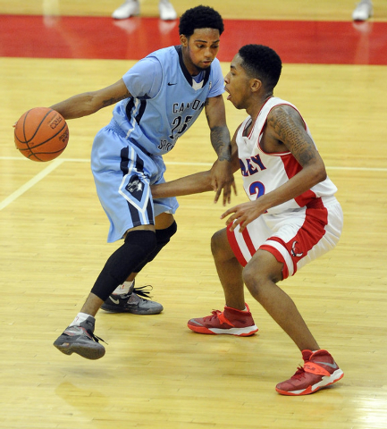 Canyon Springs’ Shaquile Carr, left, looks to drive past Valley’s Cameron Burton ...