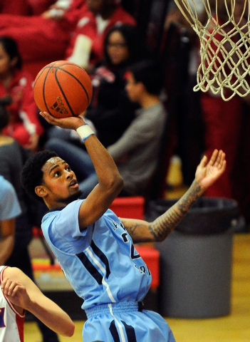 Canyon Springs’ Shaquile Carr, left, looks to drive past Valley’s Cameron Burton ...
