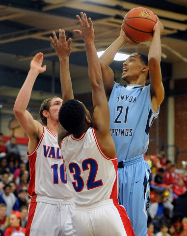 Canyon Springs’ Darrell McCall shoots over Valley’s Spencer Mathis, left, and Ca ...