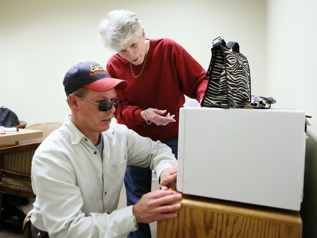 Student Chuck Hall, left, feels buttons on a microwave as instructor Jean Peyton talks to him during Blindconnect’s Transition2 class at CSN, Feb. 7. (Ronda Churchill/View)