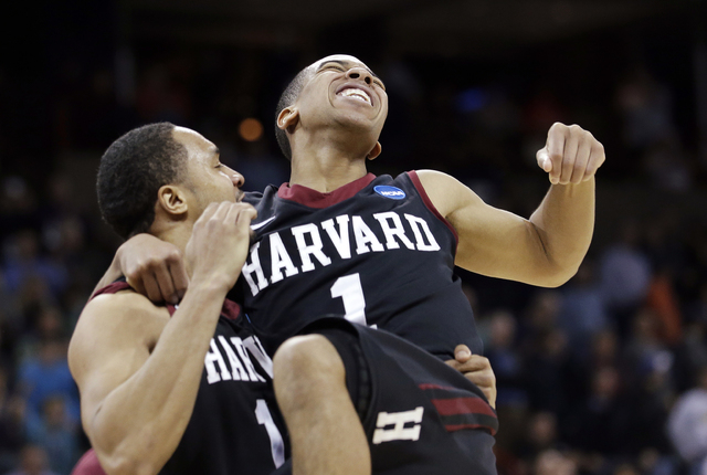 Harvard's Siyani Chambers, right, leaps into the arms of teammate Brandyn Curry after the team beat Cincinnati in the second round of the NCAA college basketball tournament in Spokane, Wash., Thur ...