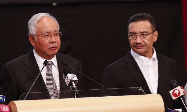 Malaysia's Prime Minister Najib Razak, left, and acting transport minister Hishammuddin Hussein speak Monday during the press conference for the missing Malaysia Airlines jet, MH370, at Putra Worl ...