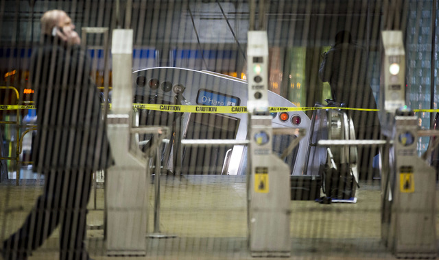 A derailed Chicago Transit Authority train car rests on an escalator at the O'Hare Airport station early Monday in Chicago. More than 30 people were injured after the eight-car train plowed across ...
