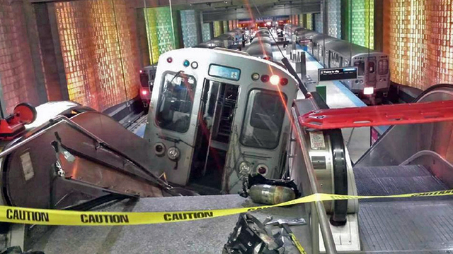 A Chicago Transit Authority train car rests on an escalator at the O'Hare Airport station after it derailed early Monday in Chicago. More than 30 people were injured after the train "climbed over ...