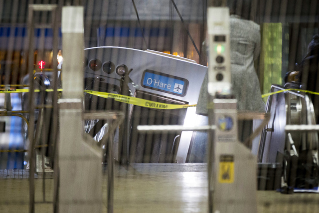 A derailed Chicago Transit Authority train car rests on an escalator at the O'Hare Airport station early Monday in Chicago. More than 30 people were injured after the eight-car train plowed across ...