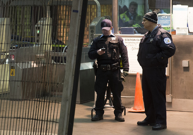 Chicago Police work the scene where a Chicago Transit Authority derailed at the O'Hare Airport station early Monday in Chicago. More than 30 people were injured after the eight-car train plowed ac ...