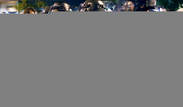 One man confronts the line of advancing Tucson Police Officers as they try to disperse an unruly crowd of disappointed fans in Maingate Square, Saturday, March 29, 2014, Tucson Ariz. after Arizona ...