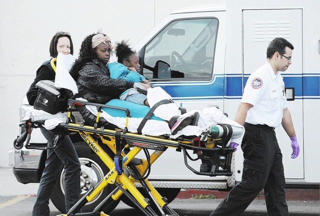 EMTs bring people to an ambulance at a Food4Less grocery store at Sahara Avenue and Eastern Avenue Saturday, March 1, 2014. Many we're injured when a woman in her 80's drove her truck into the sto ...