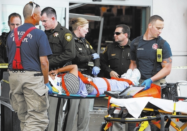 Clark County firefighters prepare a woman for transport to the hospital in front of a Food4Less in Las Vegas Saturday, March 1, 2014. An elderly woman drove through the front entrance of the groce ...