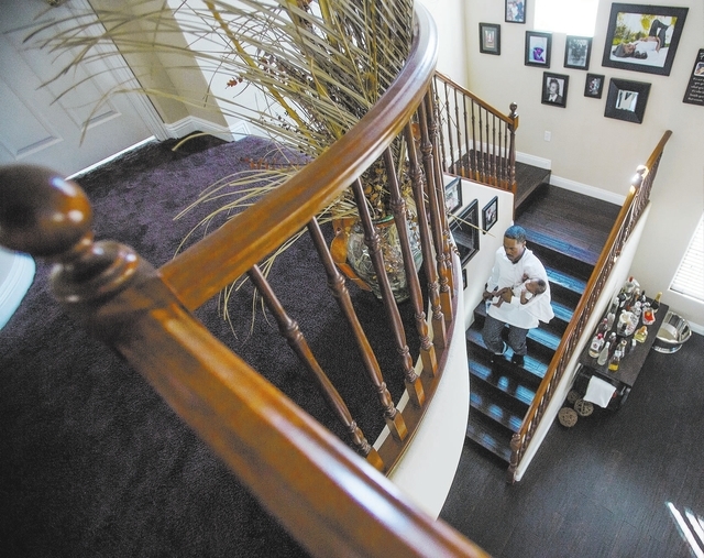 Deon Derrico carries six month old Deniko down the steps of their home in North Las Vegas on Monday, March 24, 2014. Deon Derrico's wife had quintuplets on Sept. 6.(Jeff Scheid/Las Vegas Review-Jo ...