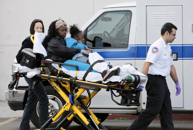 EMTs bring people to an ambulance at a Food4Less grocery store at Sahara Avenue and Eastern Avenue Saturday, March 1, 2014. Many we're injured when a woman in her 80's drove her truck into the sto ...